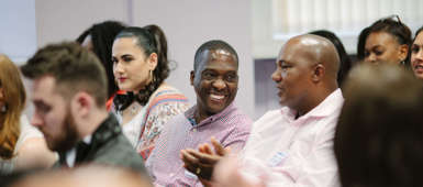 2 mean having a conversation and laughing sat down at a conference